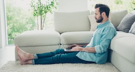 Person sitting on white area rug in living room